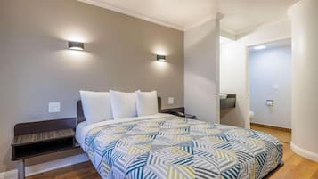 A bedroom with a bed, bedside tables, and a nightstand.
