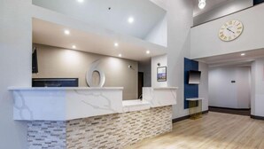 A reception area with a marble counter, a clock, and a stone wall. - 2 Full Beds | Non-Smoking, Micfridge (Auburn)