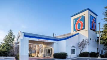 A motel with a prominent '6' sign, a clear entrance, and a parking lot.