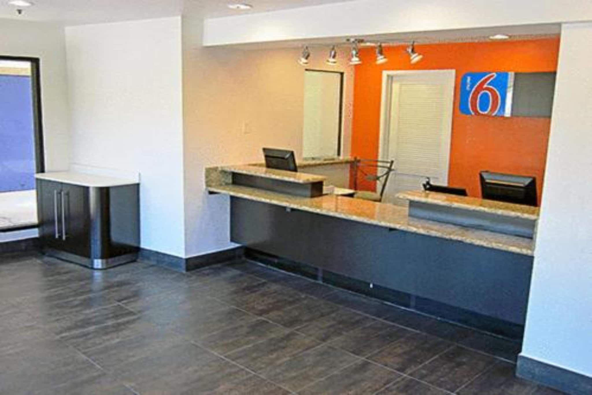 A reception area with a counter, a door, and a number sign.