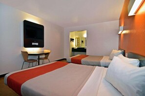 Quarto de hotel com duas camas, uma escrivaninha e uma televisão.