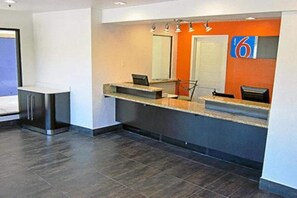 A reception area with a counter, a door, and a number sign.