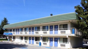 A motel with a green roof, multiple rooms, and a parking lot. - MS6 King City | 1 Queen Bed | NS MicFridge (King city)