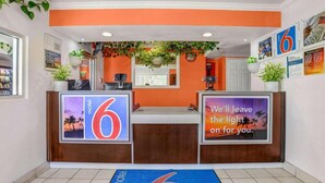A hotel reception area with a number 6 sign, a blue mat, and a message on the wall. - MS6 King City | 1 Queen Bed | NS MicFridge (King city)