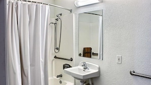 Un baño con cortina de ducha, bañera, lavabo y espejo.