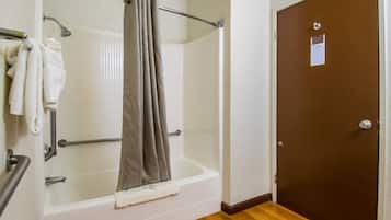 A bathroom with a bathtub, shower, and a door.