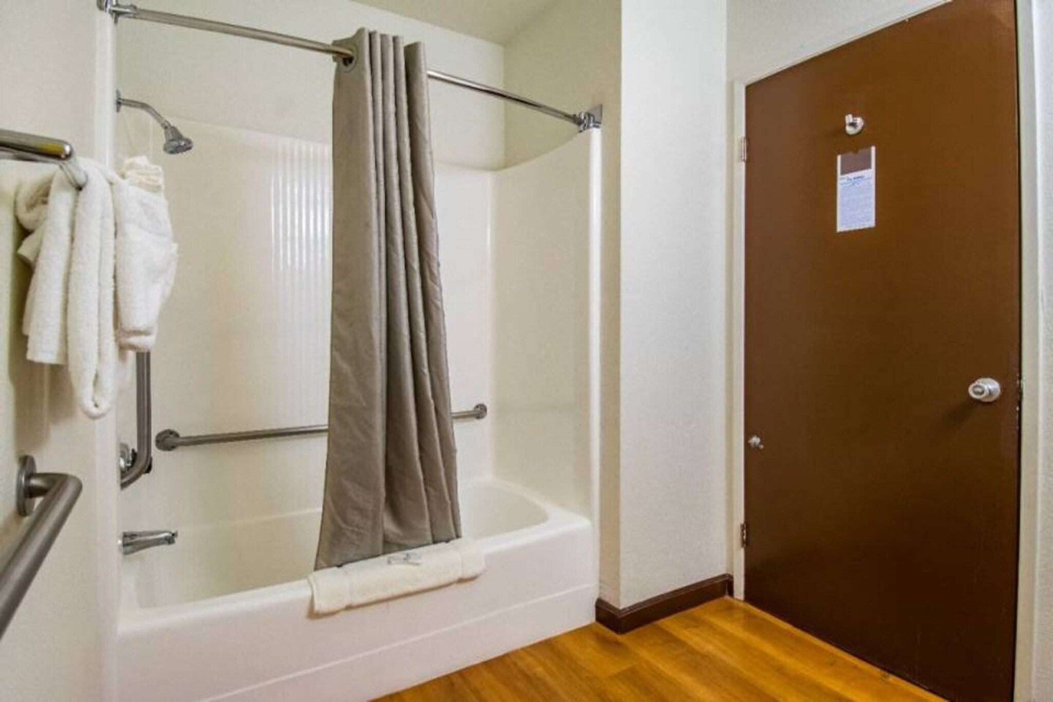 A bathroom with a bathtub, shower, and a door.
