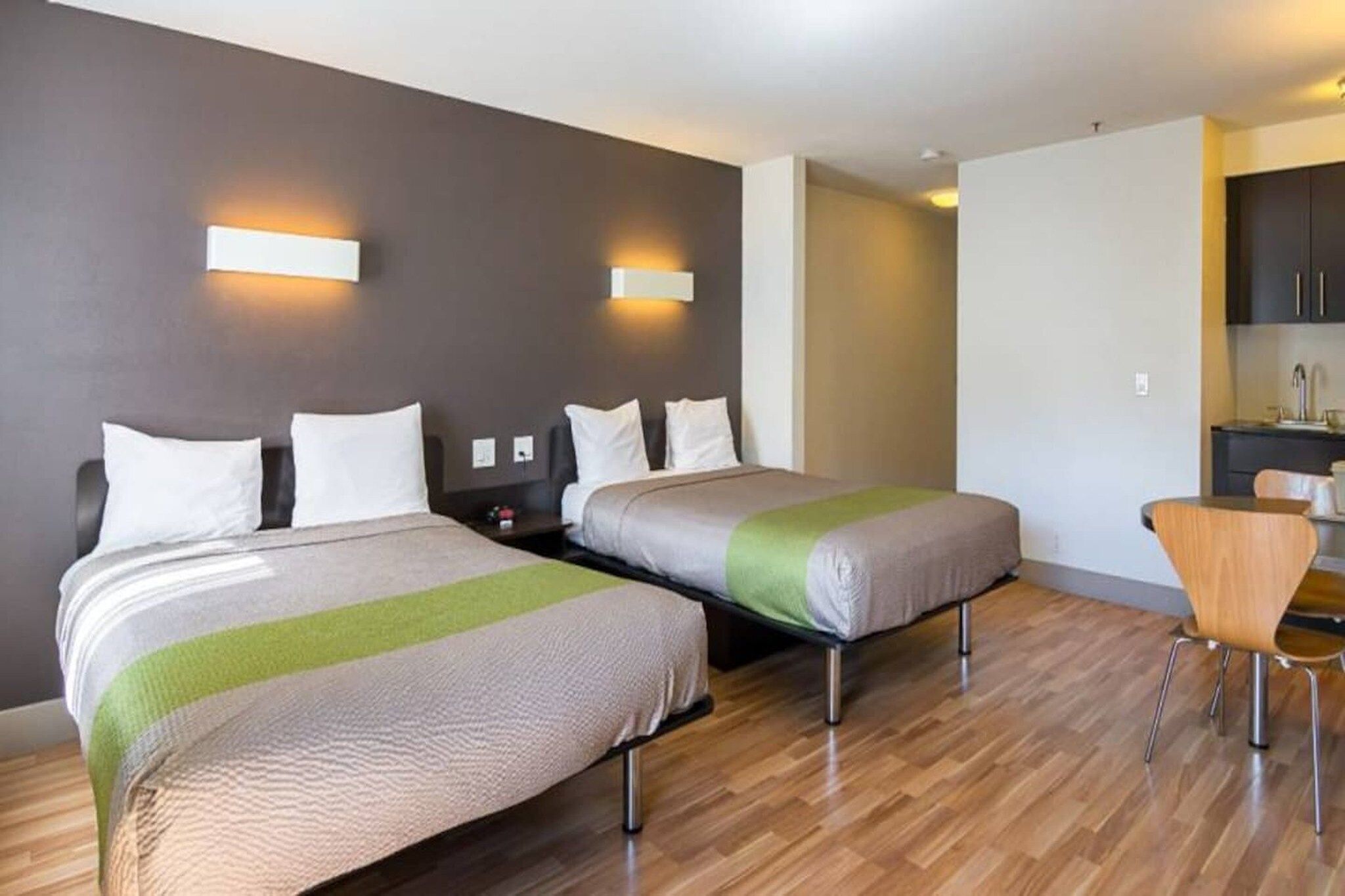 Une chambre d’hôtel avec deux lits, un bureau et une chaise.