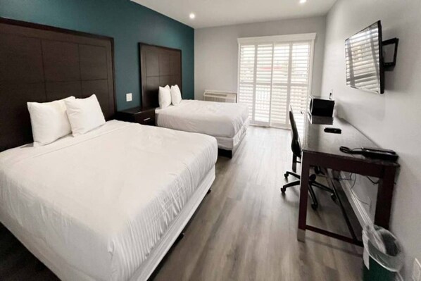 Una habitación de hotel con dos camas, un escritorio y una silla.
