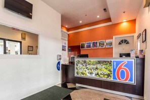 A reception desk with a sign reading 'We'll leave the light on for you.' - 1 King Bed | Non-Smoking (San Rafael)