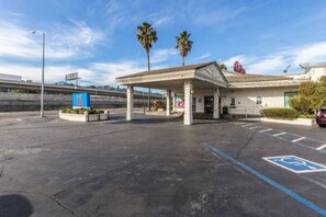 A gas station with a canopy, a handicap parking sign, and palm trees in the background. - 1 King Bed | Non-Smoking (San Rafael)