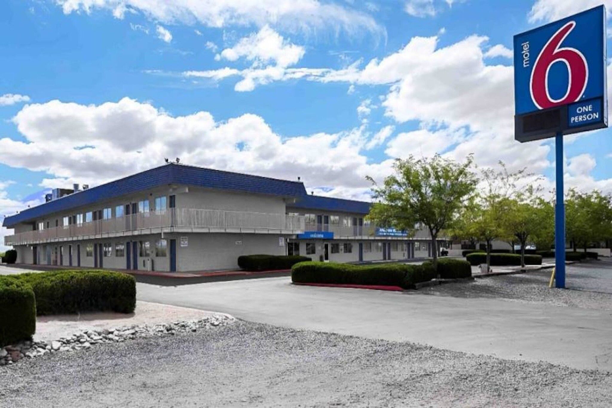 Un motel avec une grande enseigne indiquant : « 6 chambres, une personne par chambre ».
