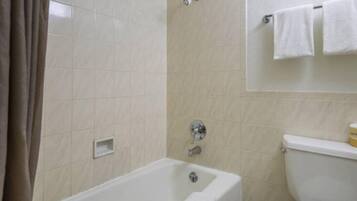 Un baño con bañera, inodoro y zona de ducha.