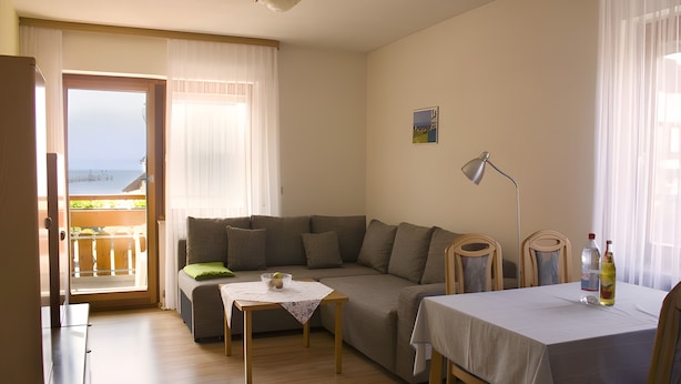 Una sala amueblada con sofá, una mesa y vistas al balcón.