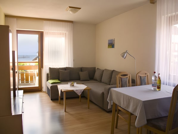 Una sala amueblada con sofá, una mesa y vistas al balcón.