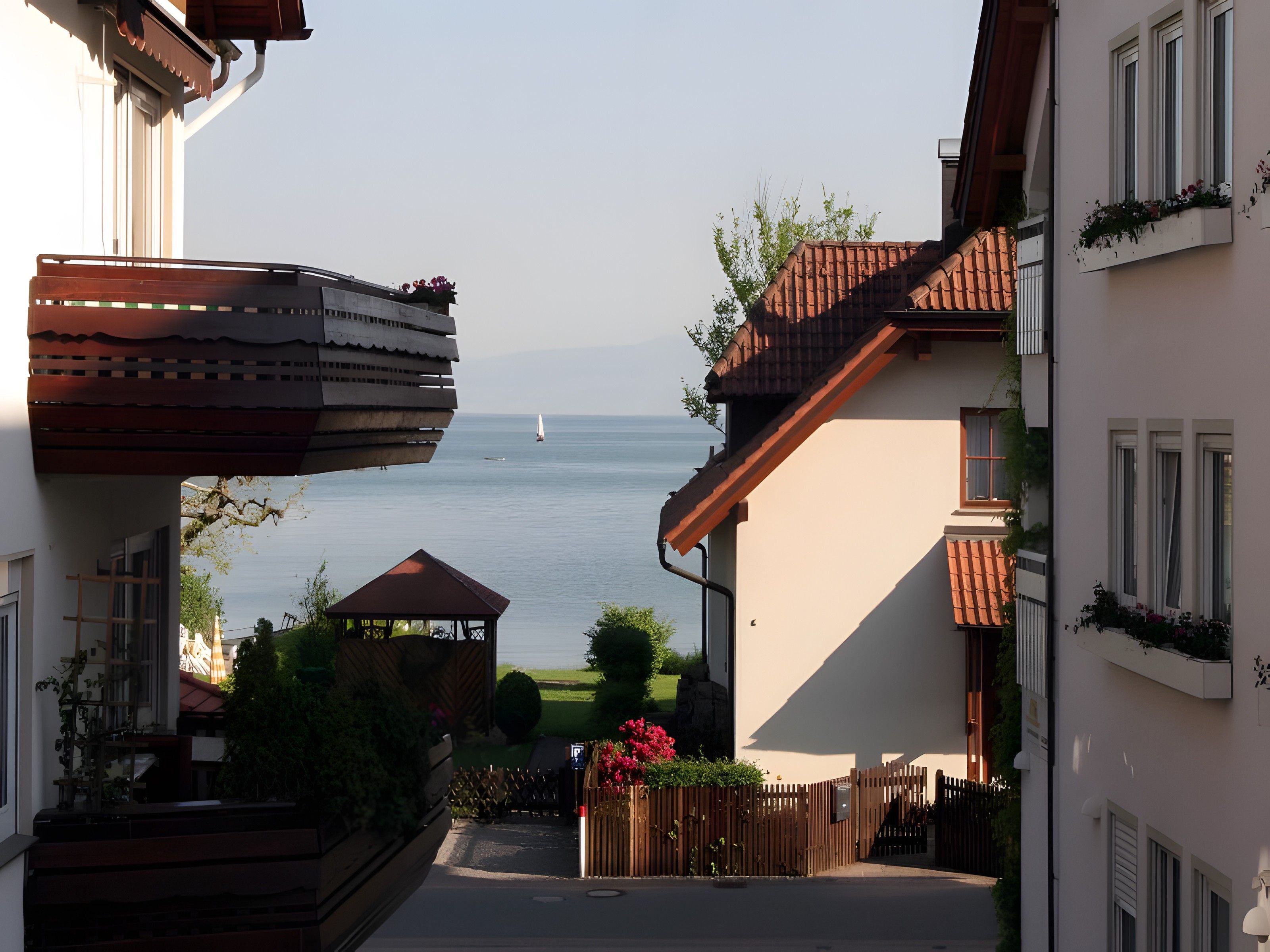 Une rue résidentielle avec vue sur la mer, agrémentée d’un belvédère et d’une clôture en bois.