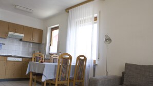 Un espacio habitable funcional con comedor, kitchenette y sofá.