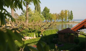 A garden with a gazebo, a pond, and trees. - Apartment 'Typ B 20' with Lake View, Shared Garden and Wi-Fi (Immenstaad am Bodensee)