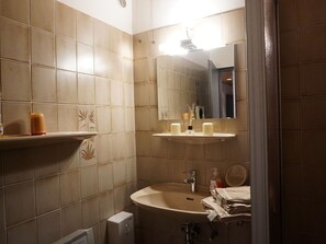 Ein Badezimmer mit Waschbecken, Spiegel und Handtuchhalter.