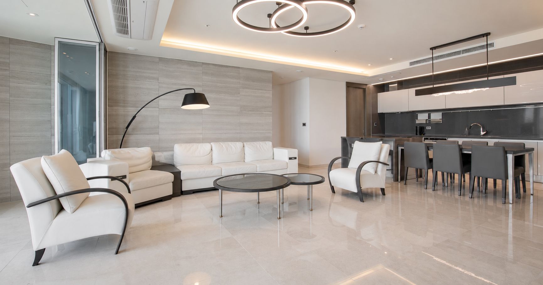 Una sala de estar moderna con un sofá, sillones y una mesa de centro.