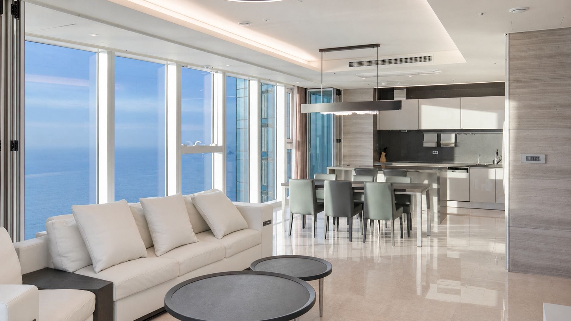 Un interior moderno con sofá, zona de comedor y cocina.