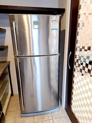 A stainless steel double-door refrigerator with a digital display and a sticker on the top right. - Luxurious 2-Bedroom Condo with Pool View near BTS Ekkamai Station (Khwaeng Khlong Tan Nuea)