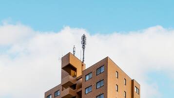 A multi-story building with a brick facade, a visible entrance, and a clear sky.