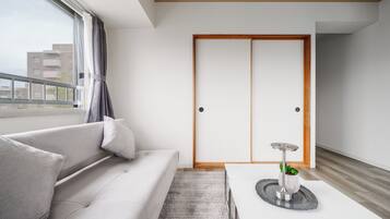 Una sala de estar moderna con un sofá, una mesa de centro y un ventanal corredizo.