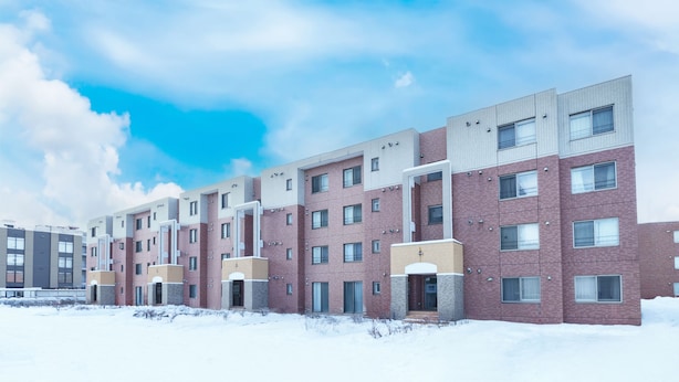 A multi-story residential building with a brick facade, multiple windows, and a flat roof. - E-US Naebo 403 (Sapporo)