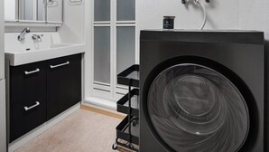 A modern bathroom with a large washing machine, a sink, and a mirror. - E-US Naebo 403 (Sapporo)