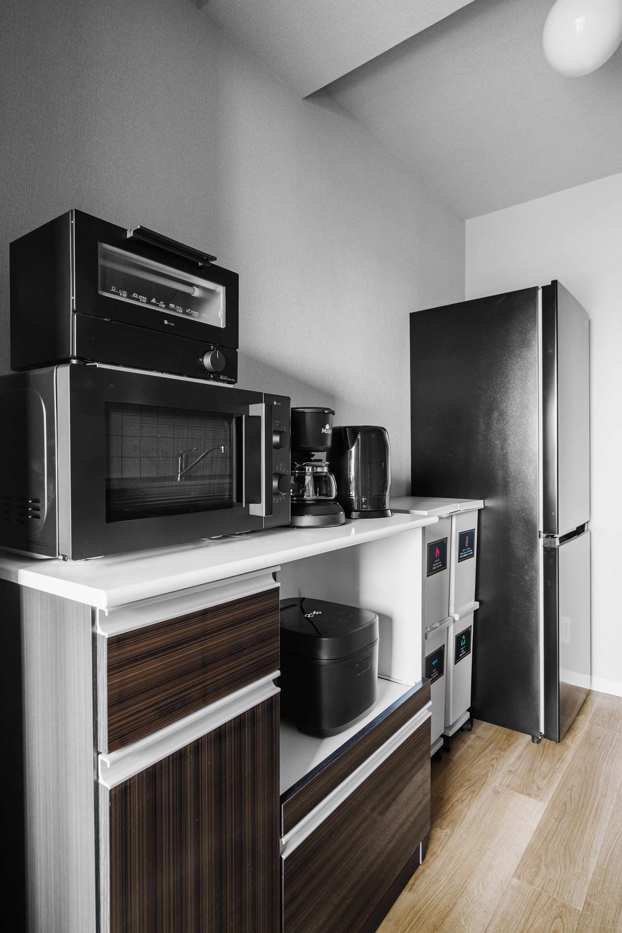 A modern kitchen with a microwave, coffee maker, and refrigerator.