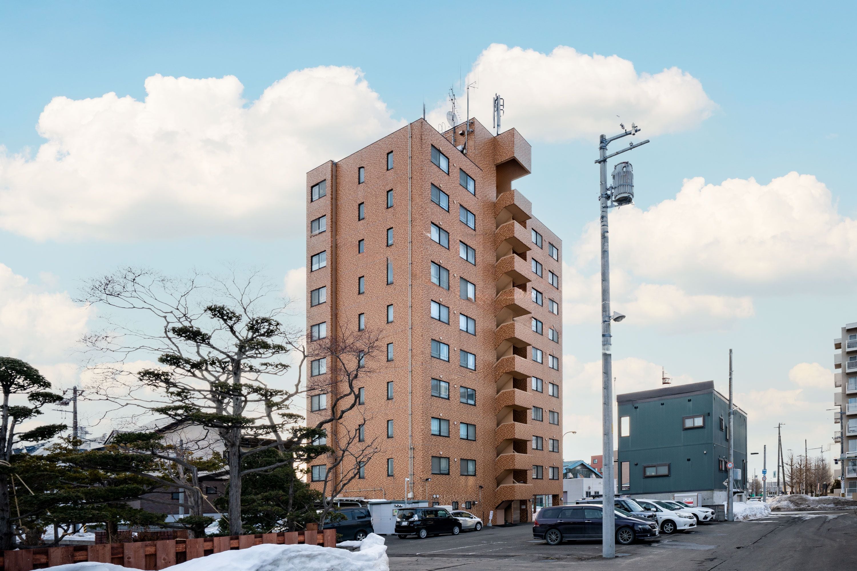A multi-story brick building with a parking lot in front.