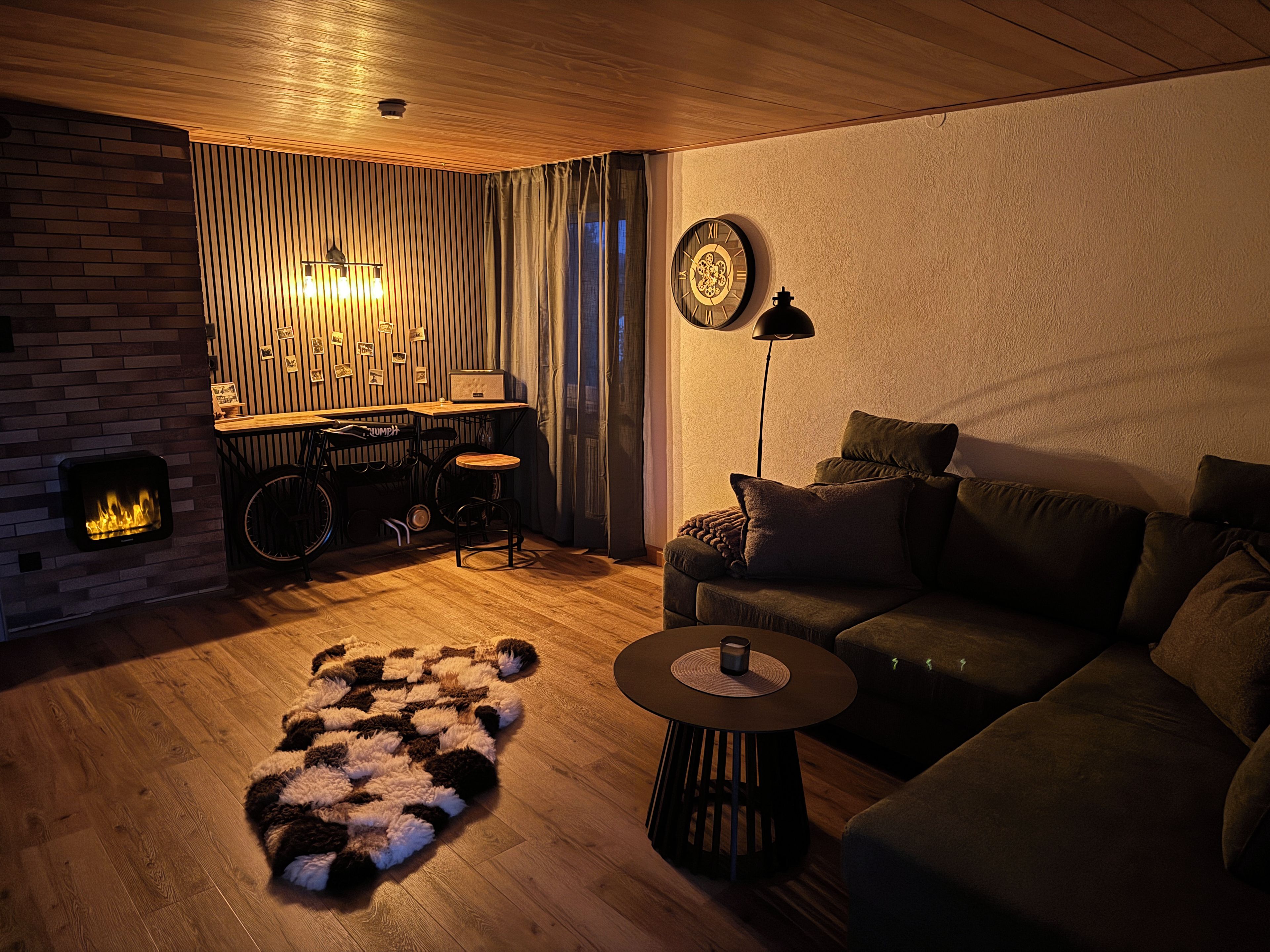 Ein gemütliches Wohnzimmer mit Kamin, einer Couch, einem Couchtisch und einem Teppich.
