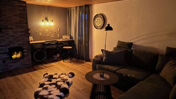 Ein gemütliches Wohnzimmer mit Kamin, einer Couch, einem Couchtisch und einem Teppich.
