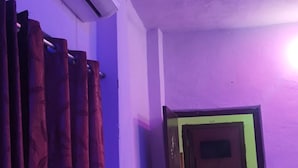 Una habitación con paredes moradas, una silla roja y un equipo de aire acondicionado.