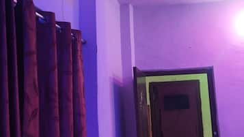 A room with purple walls, a red chair, and an air conditioning unit.