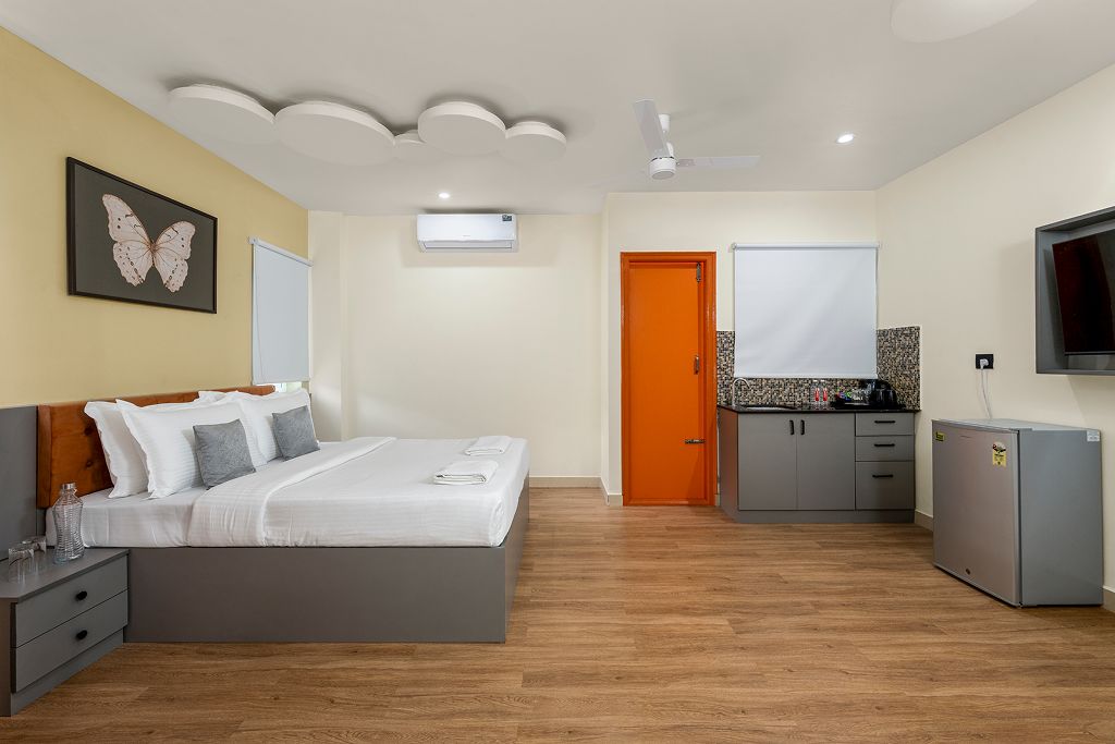 A modern bedroom with a bed, bedside table, and a wall-mounted TV.