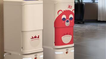 Dos máquinas expendedoras con diseño de oso, una con una corona y otra con un bocadillo que dice 'HI'.