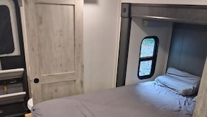 Ein kleines Schlafzimmer mit einem Bett, einem Fenster und einer Tür.