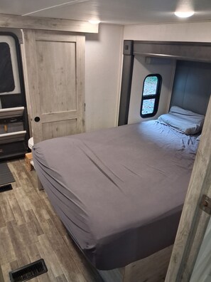 A compact bedroom with a bed, a small window, and a door. - Luxury King beds Full Kitchen 5 min from Smoky Mountains 2 storys (Cosby)