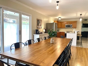A dining area with a wooden table, chairs, and a vase of greenery. - Hot Tub | Sleeps 18 | Game Room | Near Notre Dame (South Bend)