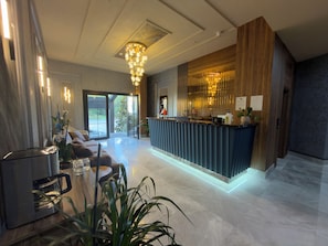 A modern hotel lobby with a reception desk, seating area, and a large window offering a view of the outdoors. - Alabi Hotels İstanbul (İstanbul)