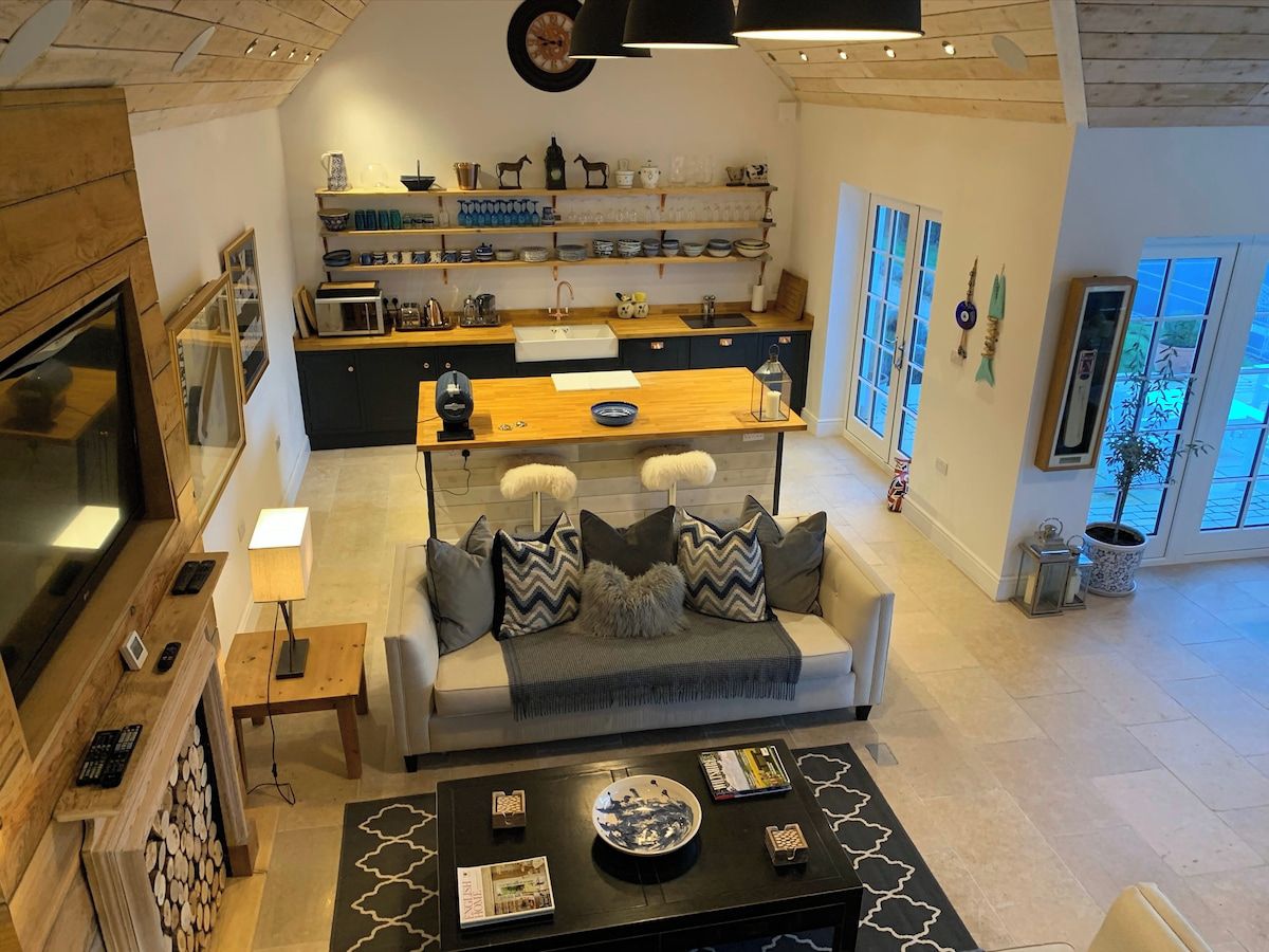 Een moderne woonkamer met een bank, salontafel en een keuken in de achtergrond.