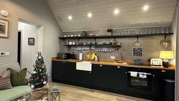 A modern kitchen with black cabinets, a wooden countertop, and a built-in oven.
