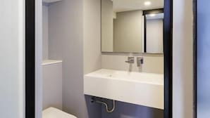 A modern bathroom with a toilet, sink, and mirror. - Siamese Residence Rama 9 Bangkok (Krung Thep Maha Nakhon)