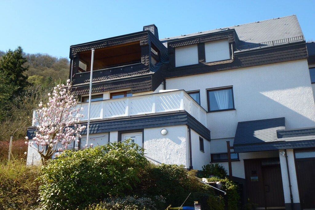 Un edificio moderno de dos pisos con un balcón en el piso superior.