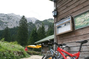 Ein Berggrundstück mit Holzhülle, einem draußen abgestellten Fahrrad und einer Speisekarte.