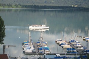 A marina with boats docked and a ferry in the background. - Holiday apartment with 1 bedroom (Rieden am Forggensee)