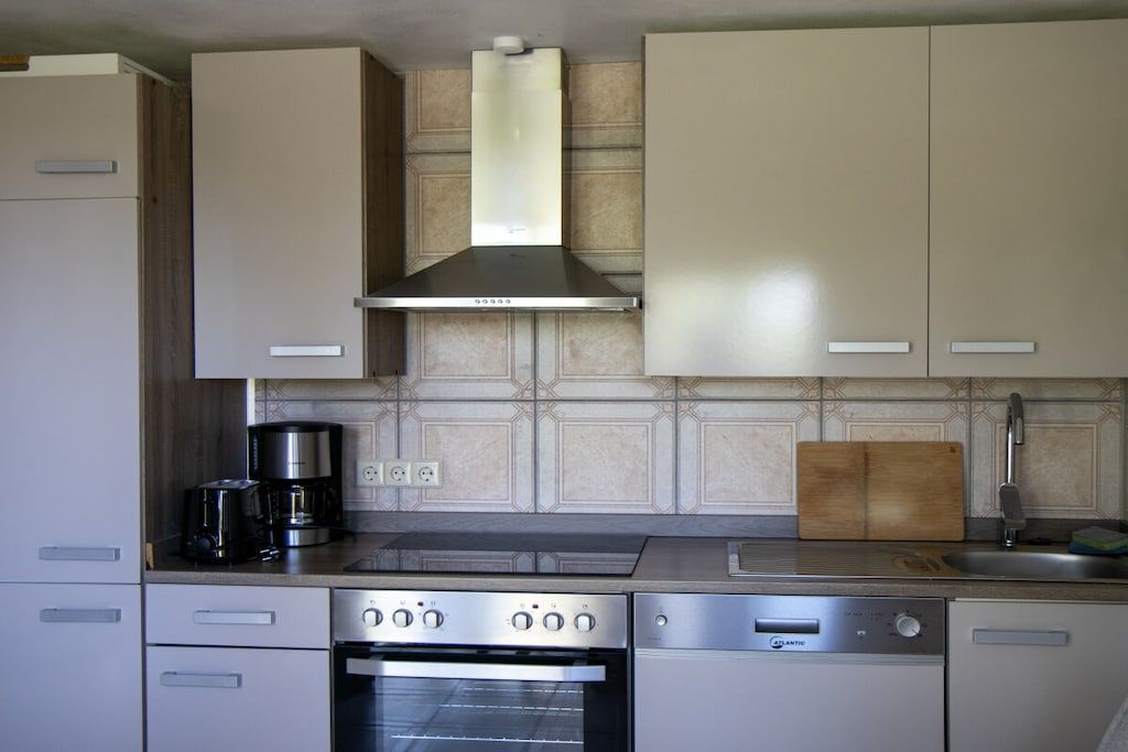 A kitchen with a stove, oven, and coffee maker.