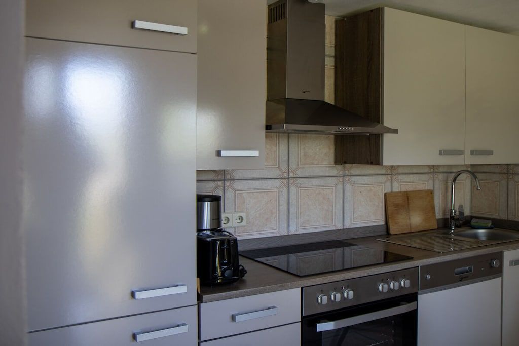A kitchen with a stove, oven, and a coffee maker on the counter.
